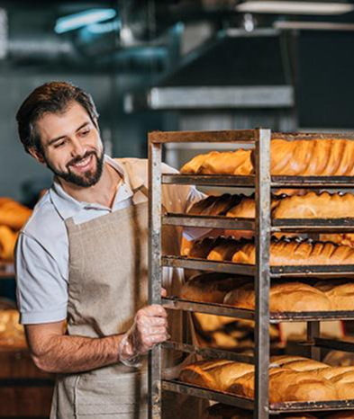 Baker Man is smiling and looking at bread